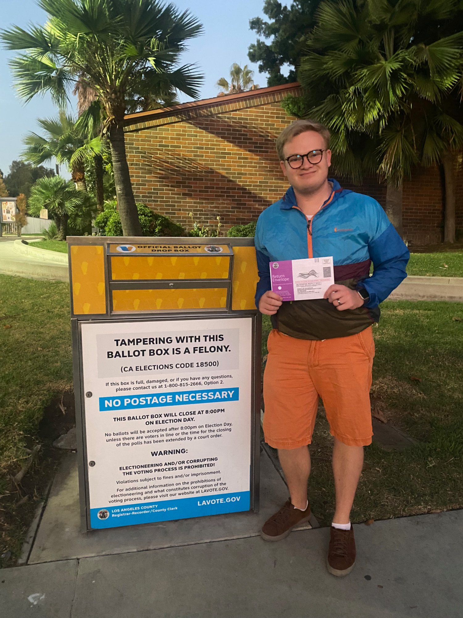 Grant standing next to an official ballot drop box in Los Angeles